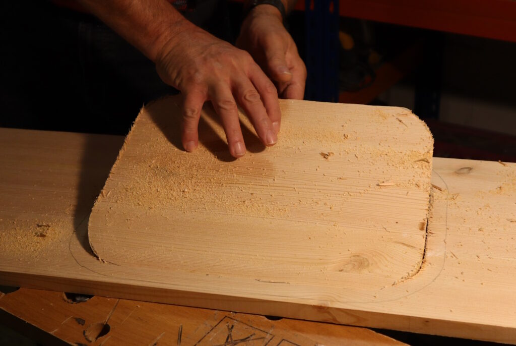 Das Foto zeigt ein fertig ausgesägtes Loch aus einem Holzbrett